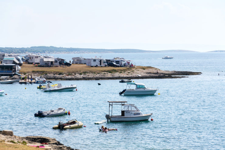 Premantura, Croatia - July 28, 2016: Tourists, caravans and boats on Kamenjak peninsula by the Adriatic sea on July 28, 2016 in Premantura, Croatia.